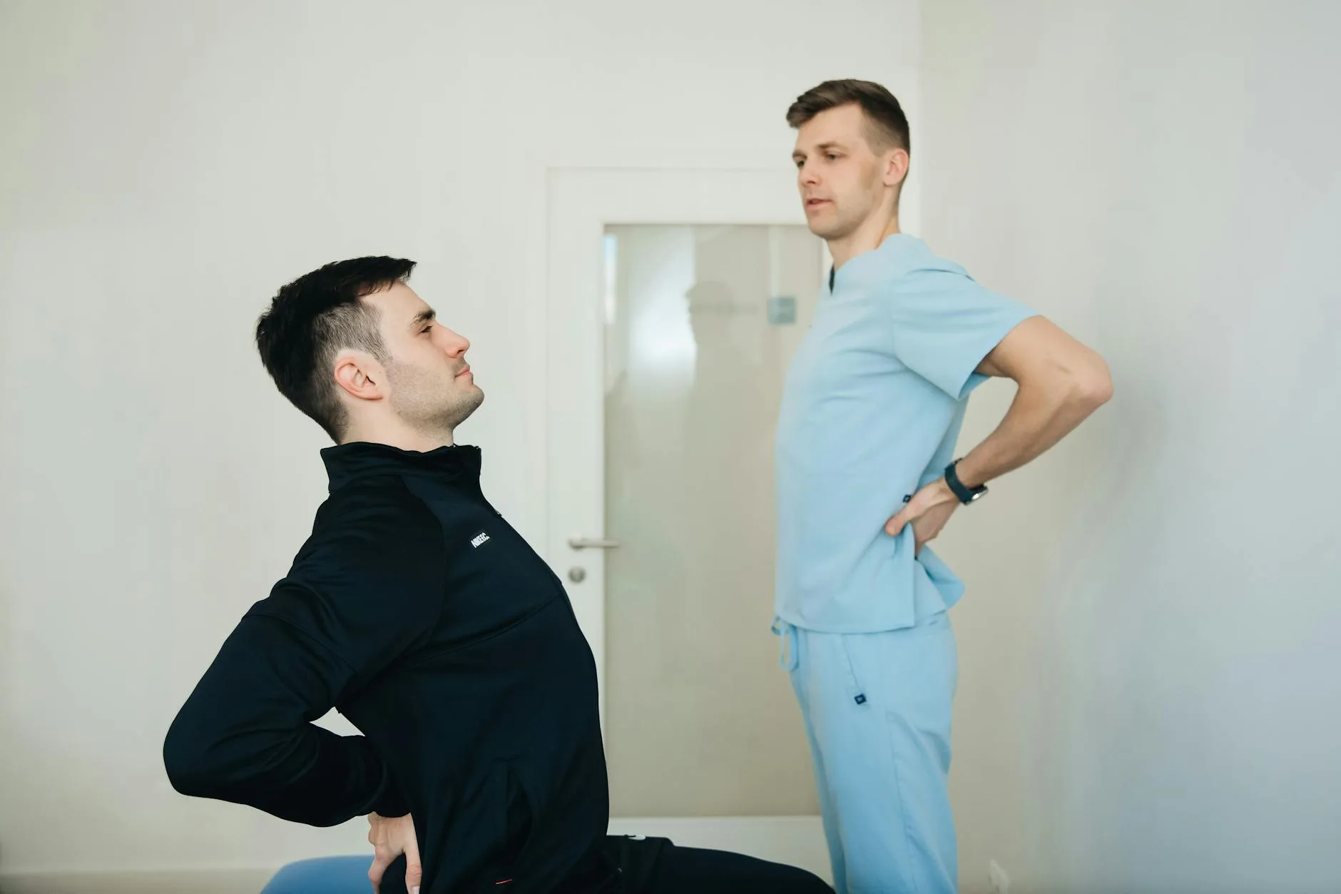Fizjoterapeuta pokazuje pacjentowi ćwiczenia odciążające dolne plecy