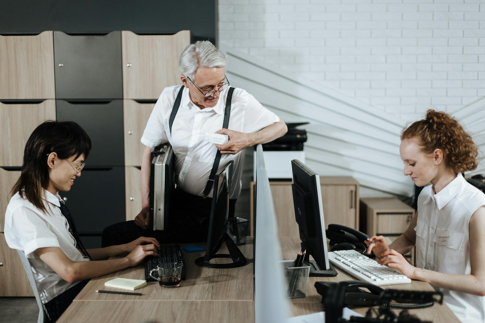 Pracownicy biurowi przy komputerach w trakcie wspólnej pracy