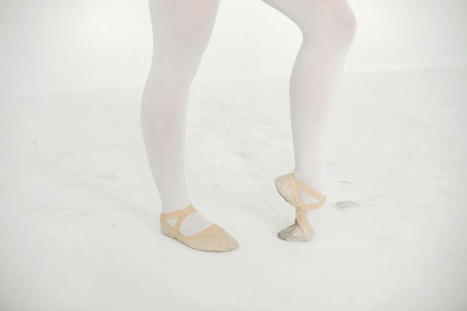 Stopy baletnicy w pointach na białym tle, przykład przeciążeń stóp