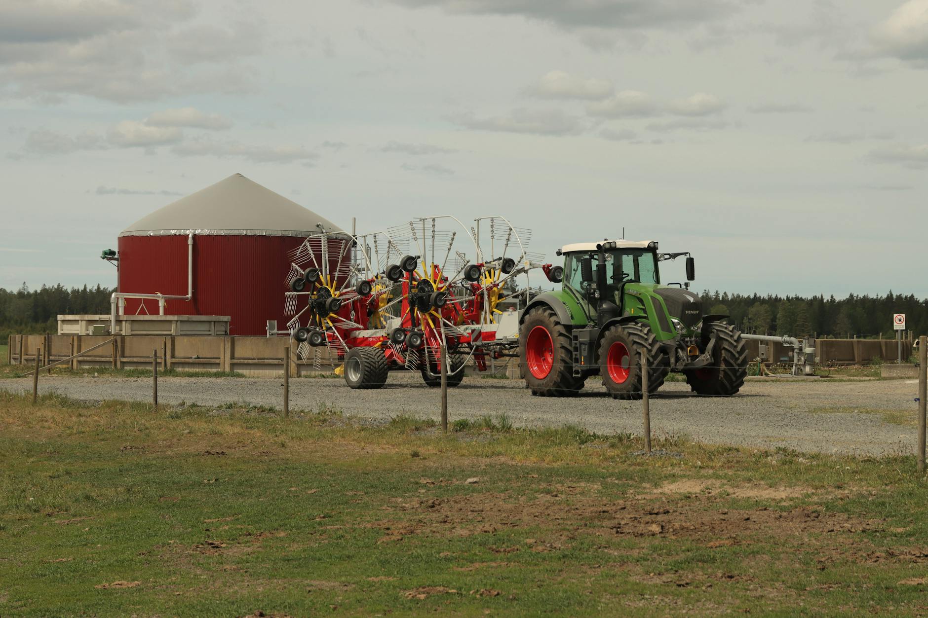 Nowoczesny traktor z przetrząsaczem na polu w gospodarstwie rolnym