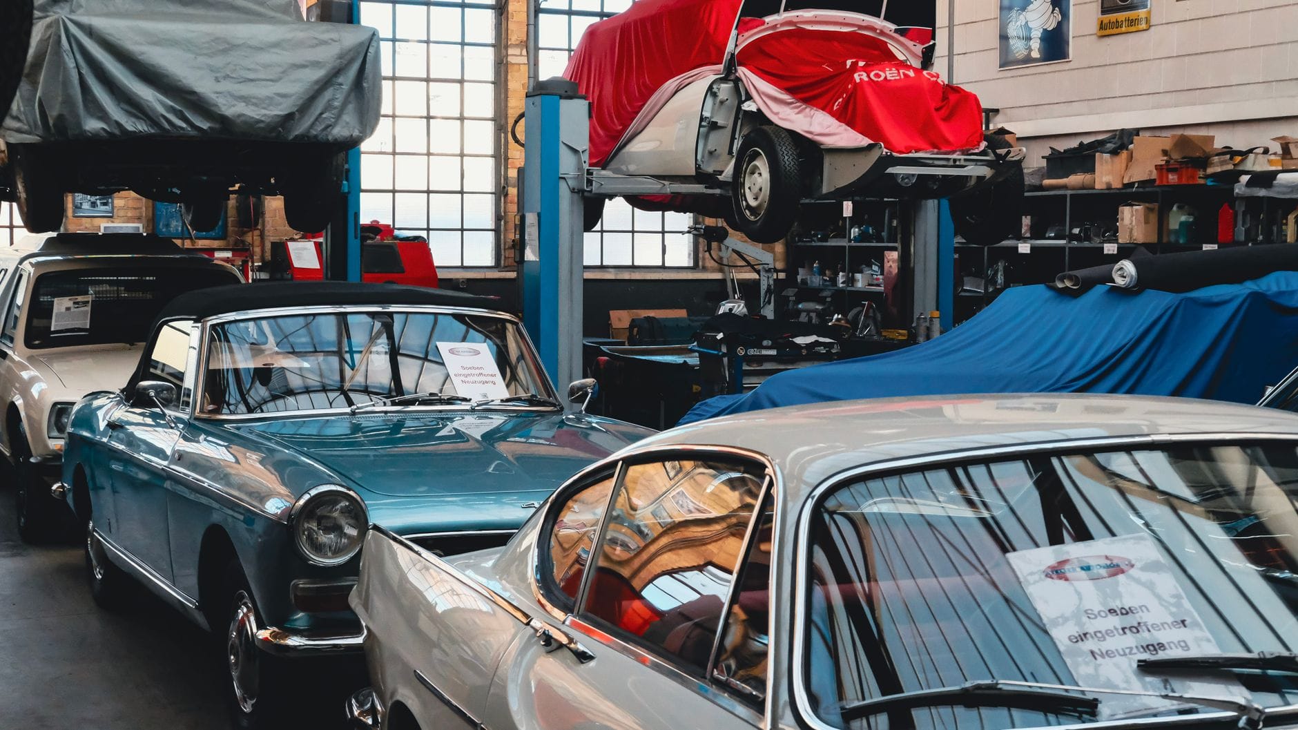 Klasyczne samochody, w tym Ford Model T, w oświetlonym garażu