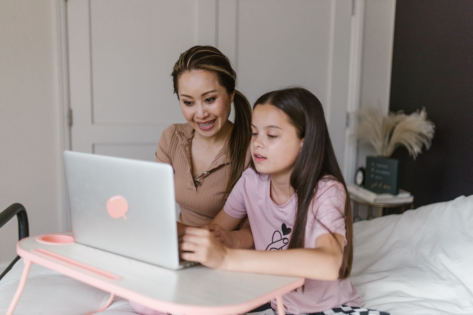 Mama i córka uczą się przy laptopie w domu
