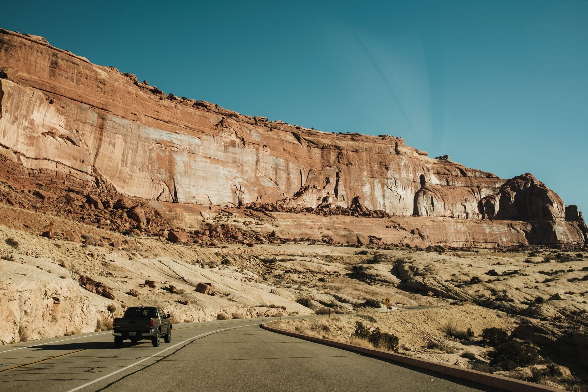 Pick-up na drodze wśród skalnych łuków w Arches National Park, Utah